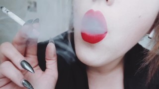 MAÎTRESSE AUX LÈVRES ROUGES PULPEUSES EN GROS PLAN FUMANT UNE CIGARETTE