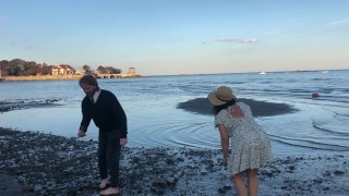 Un couple amateur dans le sable (il trouve des pierres lisses et froides)