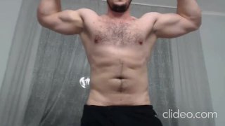 Chico alfa fuerte flexionándose en la cámara
