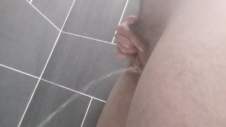 シャワーで立っておしっこをしているトランスジェンダーの男