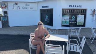 Mädchen sitzt nackt in einem Café in der Öffentlichkeit