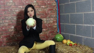 Louisa equestre che schiaccia la frutta indossando stivali