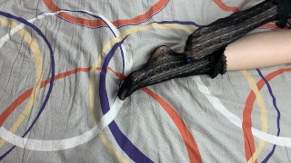 黒いレースの靴下で女の子の長い脚を愛撫