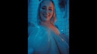 Dans la baignoire de la salle de bain jouant avec des bulles et des seins