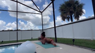 Sexy Nachbar-Yogalehrer dehnt sich am Pool