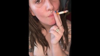 Morena fumando brinca com seus peitos