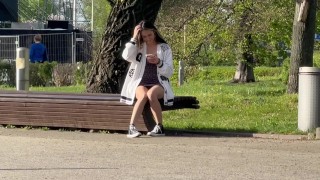 Una chica está tomando una foto de su coño desnudo en el parque.